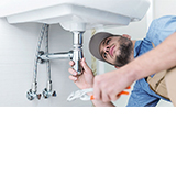 Am Waschbecken arbeitender Installateur