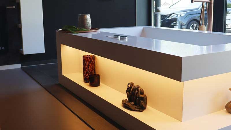 Freistehende Badewanne mit integrierter Beleuchtung und Dekoelementen.