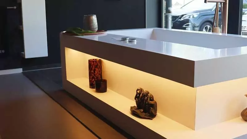 Freistehende Badewanne mit integrierter Beleuchtung und Dekoelementen.