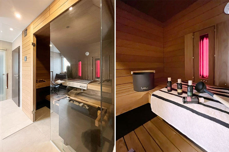 Designsauna mit Glasfront und Holzverkleidung integriert in ein modernes Wellnessbadezimmer.