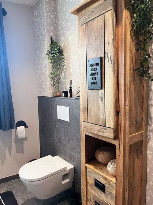 Modernes Badezimmer mit rustikalem Holzschrank, Natursteinfliesen und wandhängendem WC im nordischen Stil