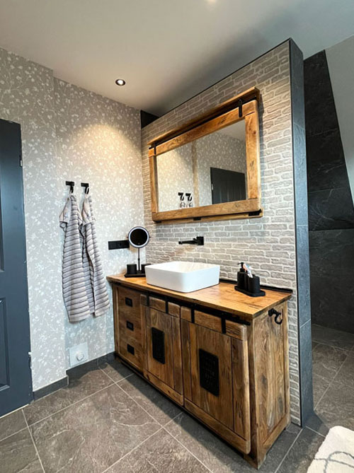 Modernes Badezimmer mit Holzwaschtisch, großem Spiegel und Natursteinfliesen im nordischen Stil